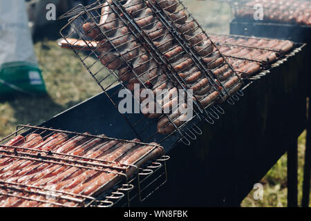 Haufen frischen leckeren Würstchen kochen auf Grill bereit für Picknick Draufsicht Stockfoto