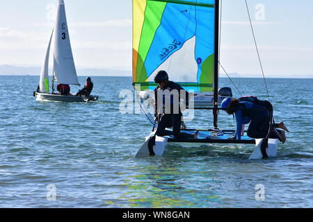 Mannschaft der Knaben ihre racing Segelyacht auf dem Wasser bereit für Ausbildung erhalten. Stockfoto