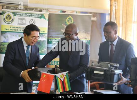 (190906) - HARARE, Sept. 6, 2019 (Xinhua) - der Präsident der Chinesischen Akademie der Wissenschaften (CAS) Bai Chunli bei (L) übergibt die anti-wilderei Ausrüstung zu Simbabwes Stellvertretender Minister für Umwelt, Tourismus und Gastlichkeit Mangaliso Ndlovu (C) in Harare, Simbabwe, Sept. 5, 2019. Die CAS und Sino-Zimbabwe Wildlife Foundation gespendet am Donnerstag gegen Wilderei Ausrüstung zu den Zimbabwe Parks und Wildlife Management Authority (Zimparks). Die 62.000-US-Dollar Wert der Ausrüstung umfasst sechs Erhaltung Drohnen, ein Laptop, Power Point Projektor und 1.000 Erste-Hilfe-Sets. (Xinhua / Zhang Yuliang) Stockfoto
