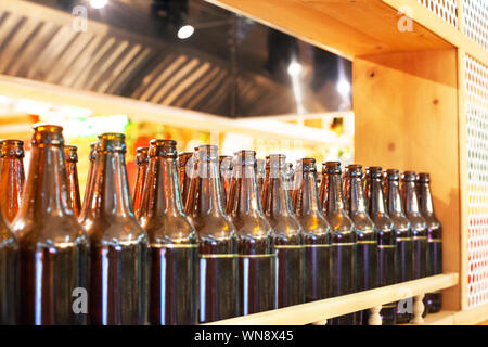 Braunes Glas Flaschen Bier in der Zeile auf Holzregal, Bar interior design, Nutzung oder Verwertung Glas Containers, Bierprobe Konzept, Nachtleben Stil Stockfoto
