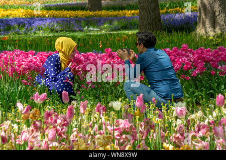 Junges Paar fotografiert zwischen Blumenbeeten im Emirgan Park, Istanbul während des Istanbul Tulpenfestes 2019 Stockfoto