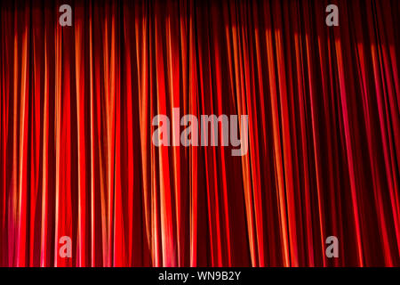 Rote Vorhänge und den Scheinwerfer im Theater zwischen zeigt. Stockfoto