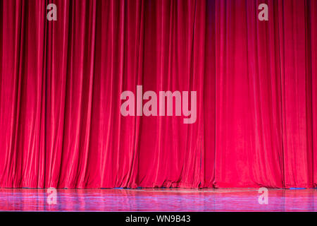 Rote Vorhänge und den Scheinwerfer im Theater zwischen zeigt. Stockfoto