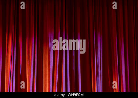 Rote Vorhänge und den Scheinwerfer im Theater zwischen zeigt. Stockfoto