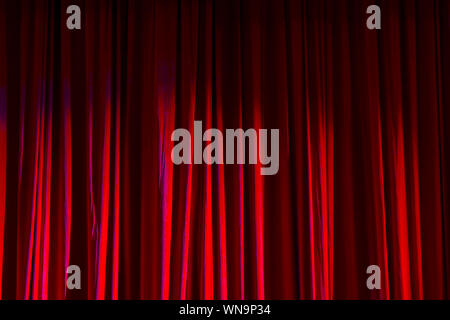 Rote Vorhänge und den Scheinwerfer im Theater zwischen zeigt. Stockfoto
