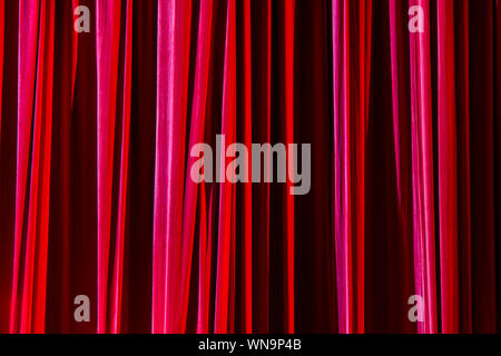 Rote Vorhänge und den Scheinwerfer im Theater zwischen zeigt. Stockfoto