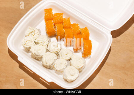 Sushi Rollen in einem weißen Kunststoff Lunchpaket zum Mitnehmen. Japanische Gerichte. Stockfoto