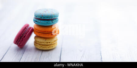 Französisch crash Macarons. Stapel von bunte Makronen auf hölzernen Tisch, Platz für Text Stockfoto