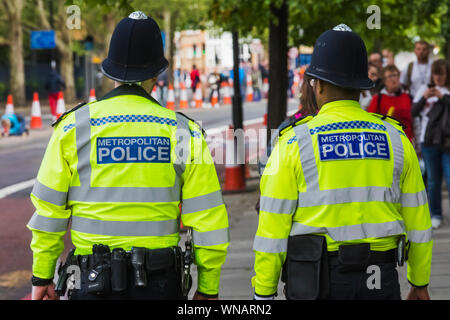 England, London, Ansicht der Rückseite zwei Metropolitan Polizisten tragen gelbe Hi-vis Jacken Stockfoto