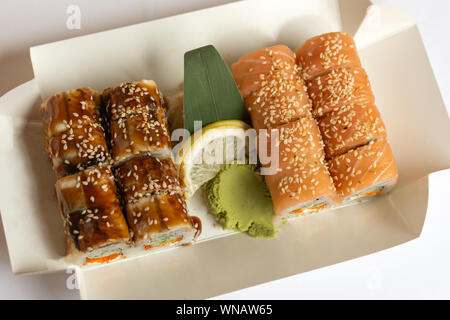 Sushi Rollen in einem weißen eco Papier Lunchpaket zum Mitnehmen. Japanische Gerichte. Stockfoto