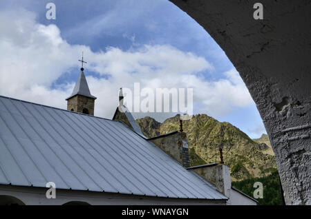 Sant'Anna di Vinadio, Piemont, Italien. Juli 2019. Hintere Ansicht von drei Vierteln der Fassade des Heiligtums. Tag Sommer mit blauem Himmel und weißen Wolken Stockfoto