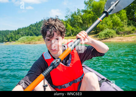 Frau Paddeln in aufblasbare Kajak fahren auf dem See, in Lokve Gorski kotar, Kroatien. Abenteuerliche Erfahrung in der wilden Natur. Stockfoto