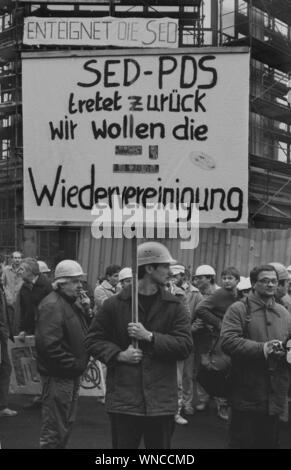 01. Januar 1990, Berlin: Demo zur Unterstützung des Runden Tisches, die Regierung Modrow nicht den Regelungen des Runden Tisches gehorchen. Daraufhin die Bauarbeiter der Baustellen auf der Friedrichstraße aufgehört zu arbeiten und die Volkskammer verschoben. Die meisten von ihnen arbeiteten für den VEB Ingenieurhochbau, wo es starke Opposition Gruppen" keine Stasi, keine SED, ansonsten verabschiede ich mich in die DDR". Beste Bildqualität, genaue Aufnahmedatum nicht bekannt. Foto: Paul Glaser/dpa-Zentralbild/ZB Stockfoto