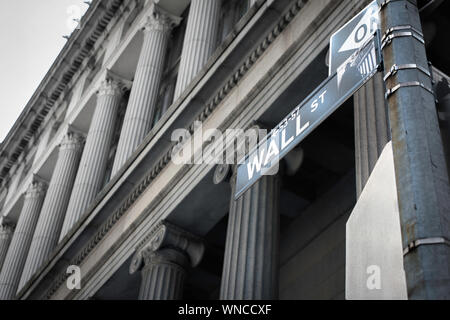 Wall Street New York, Blick auf ein düsteres Wall Street Schild gegen die Säulenfassade des alten Gebäudes der Nationalbank (heute Cipriani), NYC, USA Stockfoto