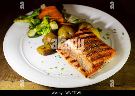 Wilde Alaska Lachs serviert in Whitehorse im Yukon, Kanada. Wird der Fisch gegrillt und mit Gemüse der Saison serviert. Stockfoto