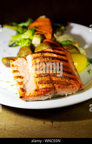 Wilde Alaska Lachs serviert in Whitehorse im Yukon, Kanada. Wird der Fisch gegrillt und mit Gemüse der Saison serviert. Stockfoto