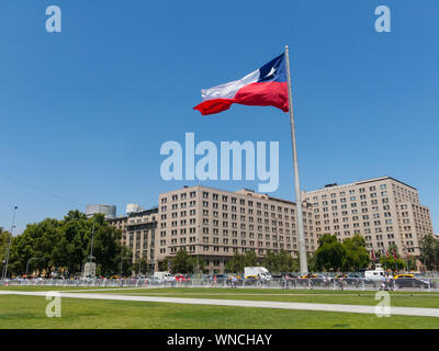 SANTIAGO DE CHILE, CHILE - 26. Januar 2018: Die chilenen zu Fuß in der Nähe der riesigen Flagge auf der Avenida La Alameda mit der Bürgerschaft Platz, in der Innenstadt von Santi