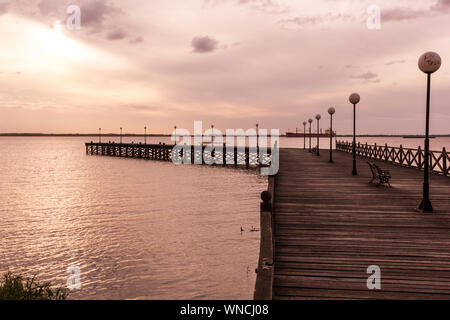 Sonnenuntergang. Allgemeine Flores Pier, vor der industriellen Laderampe von Nueva Palmira, am Uruguay Fluss. Nueva Palmira Stadt, Uruguay. Stockfoto