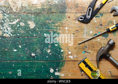 Flach vintage Zimmerhandwerk-werkzeuge auf bunten Holz- Hintergrund. Ansicht von oben Workbench mit Tischler verschiedene Werkzeuge. DIY, Holzbearbeitung, craftsmans Stockfoto