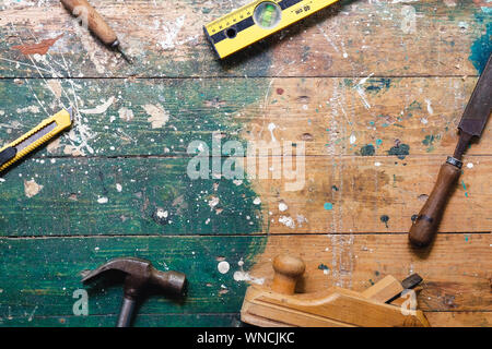 Flach vintage Zimmerhandwerk-werkzeuge auf bunten Holz- Hintergrund. Ansicht von oben Workbench mit Tischler verschiedene Werkzeuge. DIY, Holzbearbeitung, craftsmans Stockfoto