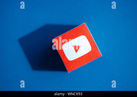 Ein Schuß von oben Papier Kubus mit den gedruckten Firmenlogo der YouTube Anwendung, die auf einem blauen Hintergrund. Stockfoto