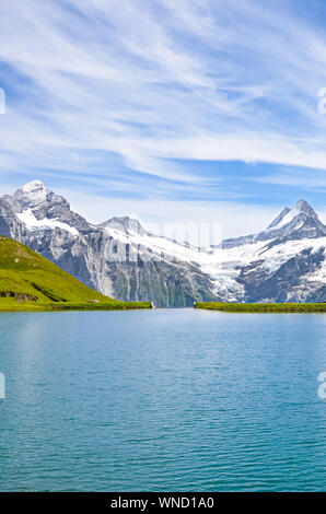 Vertikale Bild von erstaunlichen Bachalpsee in der Nähe von Grindelwald in den Schweizer Alpen mit berühmten Gipfeln Eiger, Jungfrau und Mönch fotografiert. Alpensee Landschaft. Schweiz, schneebedeckten Bergen. Stockfoto