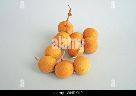 Ein Bündel von longan Früchte mit einem dünnen gelben Kruste auf einen hellen Hintergrund Stockfoto