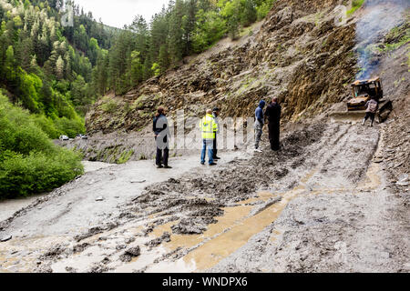 Omalo, Georgien - 11. Juni 2016: Arbeitnehmer mit Traktor der Erdrutsch am Berg Straße entfernen, Tuscheti Stockfoto