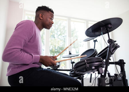 Teenager Spaß spielen elektronische Drum Kit zu Hause Stockfoto