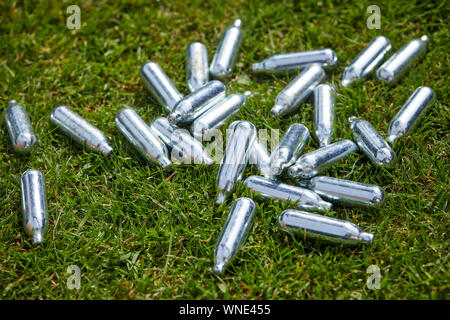 Weggeworfenen kanistern von Lachgas, Lachgas oder 'hippy crack Metall Kanister littering die Straßen. Ein farbloses Gas, das Menschen einatmen, illega Stockfoto