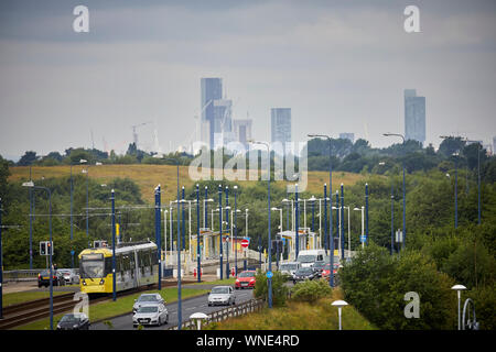 Metrolink tram in Ashton-under-Lyne Bestehen der Ashton Moss Freizeitpark (Verdeckt) mit Manchester City Skyline hinter Stockfoto