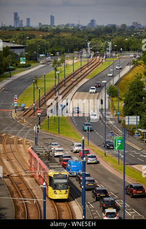 Metrolink tram in Ashton-under-Lyne Bestehen der Ashton Moss Freizeitpark (Verdeckt) mit Manchester City Skyline hinter Stockfoto