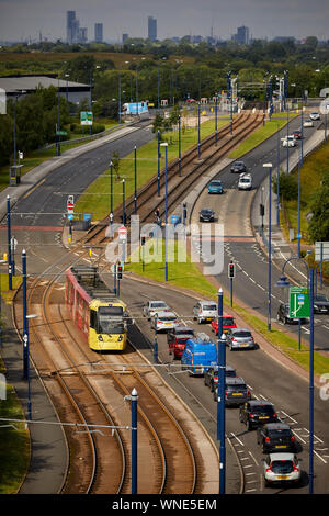 Metrolink tram in Ashton-under-Lyne Bestehen der Ashton Moss Freizeitpark (Verdeckt) mit Manchester City Skyline hinter Stockfoto