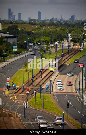 Metrolink tram in Ashton-under-Lyne Bestehen der Ashton Moss Freizeitpark (Verdeckt) mit Manchester City Skyline hinter Stockfoto