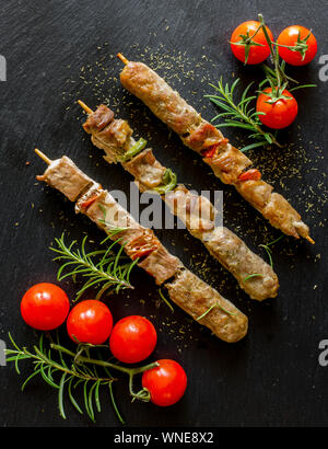 Spieße mit gemischtem Fleisch und gegrilltem Gemüse auf Schiefer Stockfoto