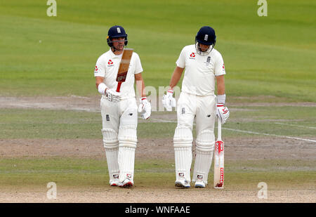 England's Rory Verbrennungen (links) feiert 50 läuft mit Teamkollege Joe Root (rechts) bei Tag drei des vierten Asche Test im Emirates Old Trafford, Manchester. Stockfoto