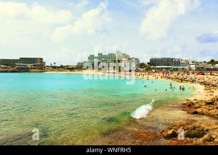 Touristen, Urlaubern & plane spotters, im Meer und auf dem Sand an Maho Beach entspannen, neben Princess Juliana International Airport, St. Maarten. Stockfoto