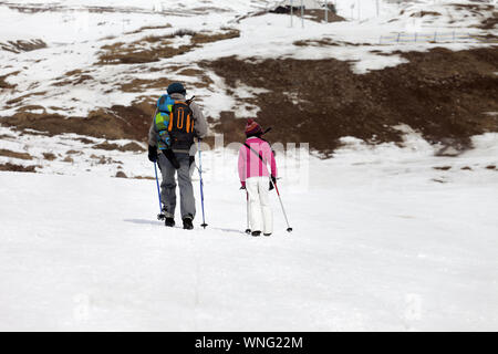 Vater und Tochter mit Skistöcken auf schneebedeckten Hang in wenig Schnee. Kaukasus, Georgien, Region Gudauri. Stockfoto