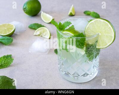 Einen Mojito Cocktail von frischer Minze und Limette in ein geschliffenes Glas Tumbler gegen einen hellen Hintergrund Stockfoto