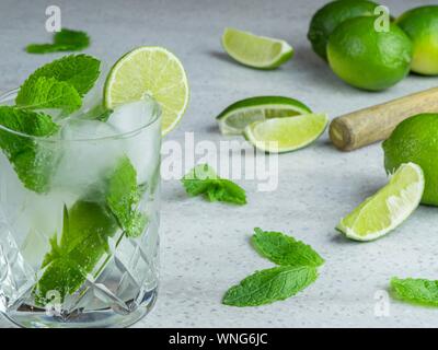 Einen Mojito Cocktail von frischer Minze und Limette in ein geschliffenes Glas Tumbler gegen einen hellen Hintergrund Stockfoto