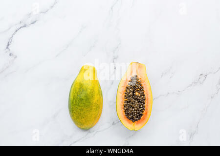 Die Hälfte der frischen Papaya auf einem weißen Hintergrund, kreative Essen Konzept, tropische Früchte flach. Platz für Text. Schließen oben mit Kopie Raum, mockup Stockfoto