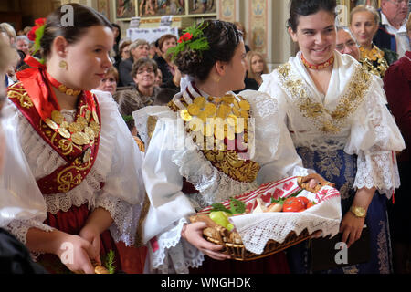 Frauen gekleidet in traditionelle regionale Trachten in der Kirche bei der Messe am Thanksgiving Tag in Stitar, Kroatien Stockfoto