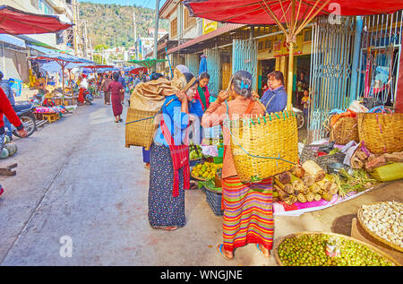 TAUNGGYI, MYANMAR - 20. FEBRUAR 2018: Die dorfbewohner mit großen Körben ein Gespräch haben, stehen am Obststand landwirtschaftlicher Markt, auf Fe Stockfoto