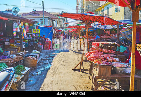 TAUNGGYI, MYANMAR - 20. FEBRUAR 2018: Die schmale Gasse der Lebensmittelmarkt mit Verkaufsständen, mit frischem Fleisch, Gemüse und Früchte der örtlichen Bauern, o Stockfoto