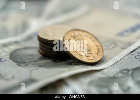 Fünf indische Rupie Münzen auf fünfhundert Rupien Banknoten gestapelt. Konzept für Geld Hintergrund. Stockfoto