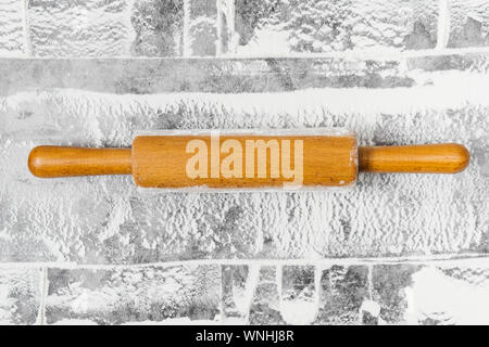 Backen flach mit Rolling Pin, Mehl auf grauem Hintergrund. Backen Menü, Rezept, hausgemachtem Gebäck Konzept. Ansicht von oben, mit Kopie Platz für Ihren Text. Stockfoto