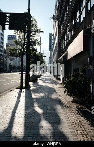 MATSUYAMA, Japan - 13 Aug, 2019: Ein vertikaler einen Steinblock Fußgängerzone mit Gebäuden und Bäumen umgeben Stockfoto