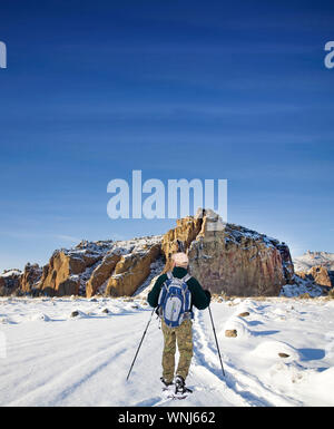 Ein Mann in Smith Rock State Park, im Zentrum von Oregon, Schneeschuhen durch eine verschneite Winterlandschaft nach einem schweren Schneesturm. Stockfoto