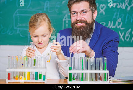 Chemie zu erklären Kid. Wie Interesse Kinder studieren. Faszinierende Chemie Lektion. Man bärtige Lehrer und Schüler mit Reagenzgläsern im Klassenzimmer. Privatunterricht. Schule Chemie Experiment. Stockfoto