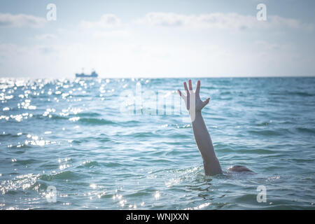 Hand der Ertrinkenden im Meer um Hilfe zu bitten. Haften aus dem Wasser Stockfoto